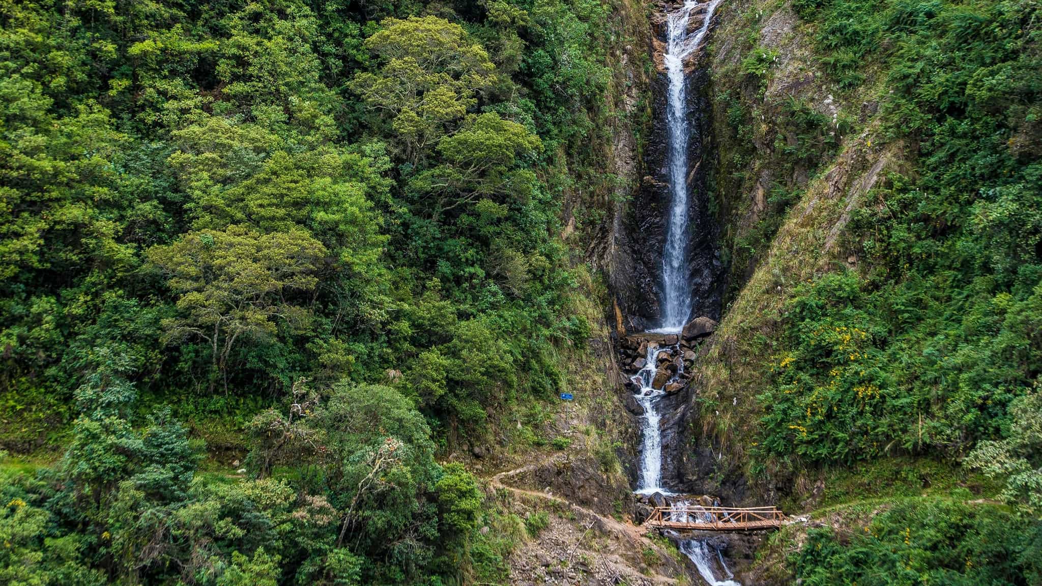 Waterfall and bridge among the forest along the Salkantay Route to Machu Picchu in Peru.