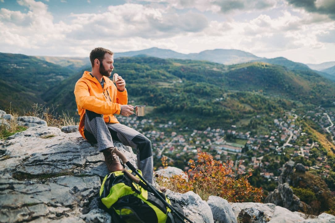 Man eating and drinking whilst on a hike