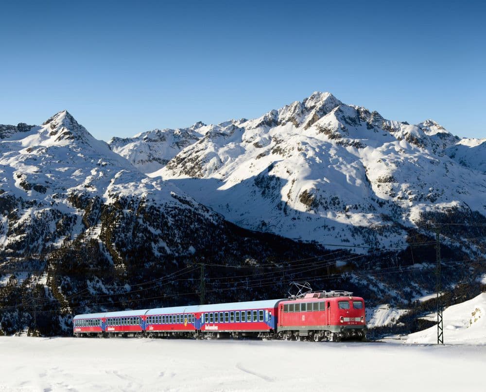 Alpine train with mountains behind. Photo Alpen Express/Treinreiswinkel