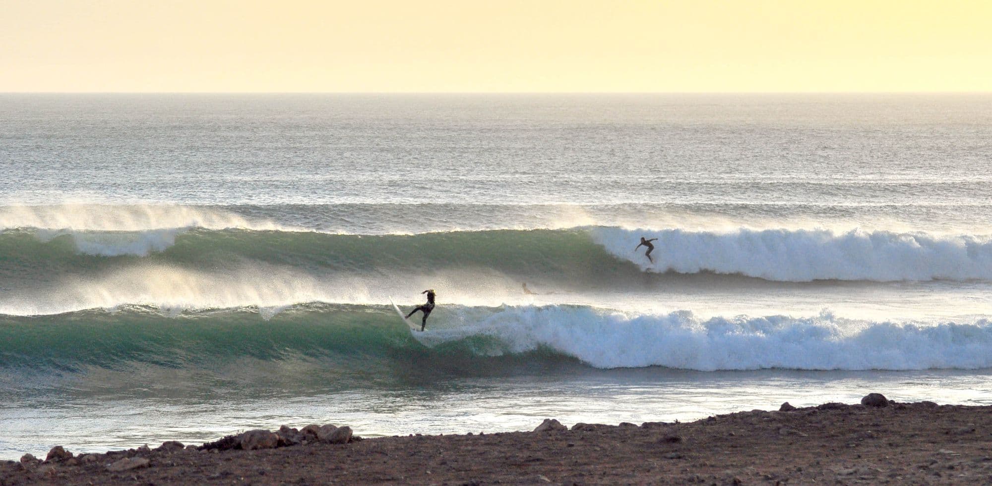 two surfers in the waves in Taghazout, Morocco