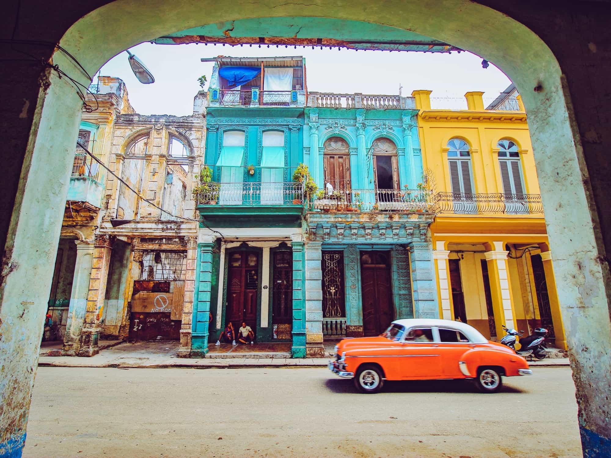 Red classic car driving through a street in Havana, Photo: Unsplash florian-wehde--mO6VoL8K2A-unsplash