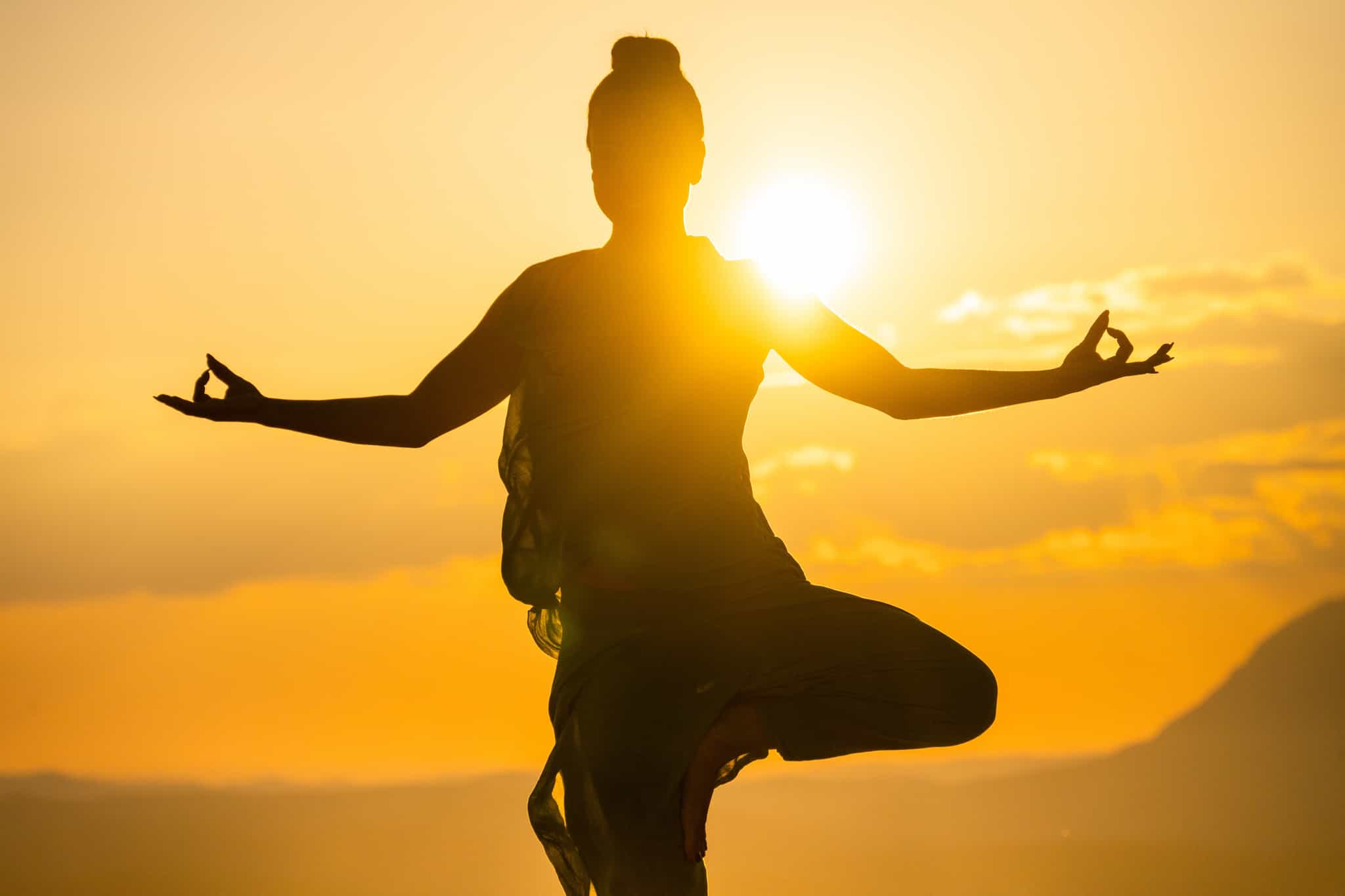 Women in yoga pose at sunrise Photo: GettyImages-1439625616