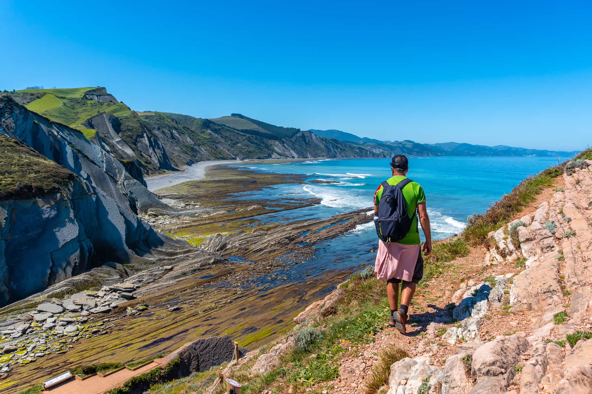 A man in Algorri cove on the coast in the Zumaia flysch, Gipuzkoa. Basque Country