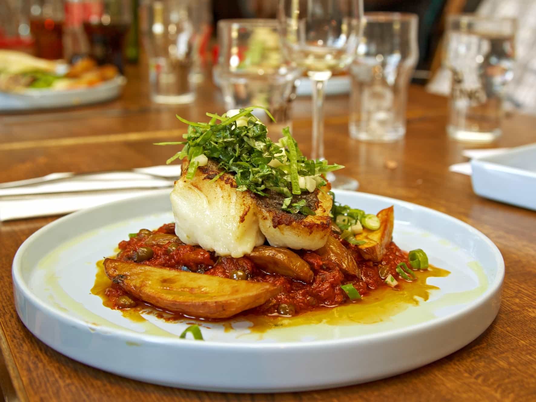 Icelandic Cod fish and tomatoes on a plate. Photo: GettyImages-187032324